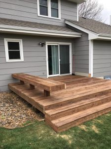 Cedar-toned greentreated wood Backyard deck and bench by Norwalk Seasonal - Des Moines, Iowa