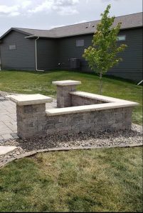 Decorative Stone Seating Wall on a patio using Unilock pavers with limestone edging by Norwalk Seasonal - Des Moines, Iowa