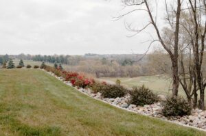 Backyard Limestone edged Shrub Garden at the top of the retaining wall Norwalk Seasonal - Des Moines, Iowa