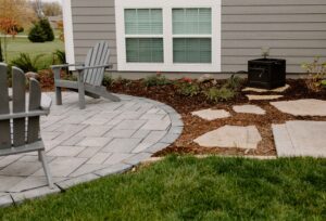Techo-Bloc Patio with Mulch Landscaping and flagstone pavers used as a walkway through the garden - Norwalk Seasonal - Des Moines, Iowa