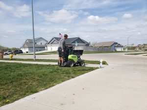 Yard seeding by Norwalk Seasonal - Des Moines, Iowa - Pictured is a man on a green commercial fertilizing buggy