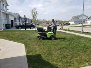 Yard Seed done by Norwalk Seasonal - Des Moines, Iowa. Pictured is a man on a green commercial fertilizing buggy