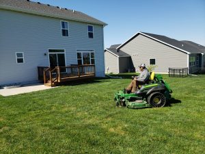 Professional Yard Care Norwalk Seasonal - Des Moines, Iowa - A Norwalk Seasonal Services Employee is pictured on a large green commercial lawn mower