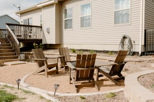 Gravel patio with two sets of Adirondack chairs with tables in between
